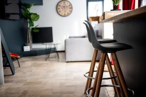 a black stool sitting at a counter in a room at Le cottage du clos des Forges in Saint-Leu-dʼEsserent +3 photos