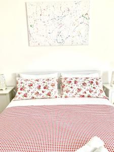 łóżko z czerwono-białą pościelą i poduszkami w obiekcie B&B Scilla Mare w mieście Scilla
