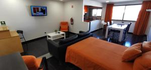 a living room with a bed and a couch and a desk at Original Apartments in Albufeira