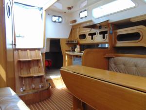Vista interior de una cabaña con mesa y banco en Jacht motorowy Calipso 750, en Ryn