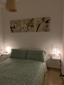 a bedroom with a bed and three pictures on the wall at B&B Scilla Mare in Scilla