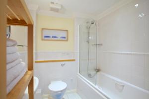 a bathroom with a shower and a toilet and a sink at Compass Point in Carbis Bay +18 photos
