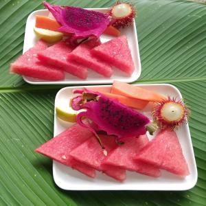 twee borden watermeloen en fruit op een tafel bij Thani Villa in Ubud