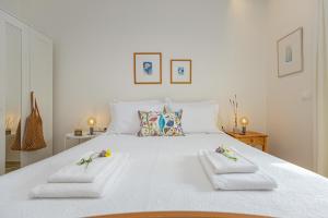 a bedroom with a white bed with towels on it at Casa MaLu Boutique Studio No 4 in Gouvia