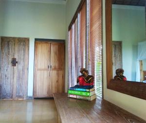 een kamer met boeken op een tafel en een spiegel bij Thani Villa in Ubud