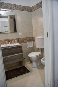 a bathroom with a toilet and a sink and a mirror at Casa dell arco Apartment in Bari +28 photos