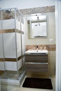 a bathroom with a shower and a sink and a mirror at Casa dell arco Apartment in Bari