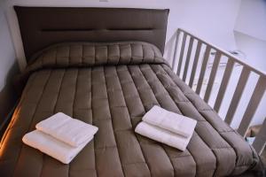 a bed with two white towels on top of it at Casa dell arco Apartment in Bari