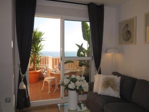 a living room with a couch and a sliding glass door at Penthouse Aloha4you in Mojácar