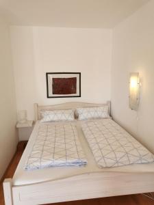 a white bed in a white room with a bed frame at Apartment Bad Reichenhall in Bad Reichenhall