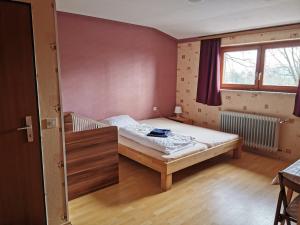 een kleine slaapkamer met een bed en een raam bij Pension Fernblick in Sankt Oswald