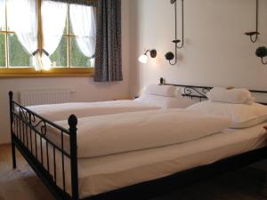 un par de camas en una habitación con ventanas en Das Edelweiss, en Aschau
