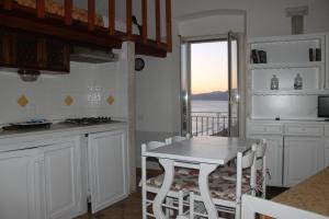 a kitchen with a table and a view of the ocean at Florenza Residence in Sperlonga