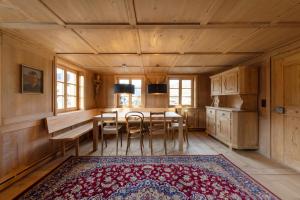 una sala da pranzo con tavolo, sedie e tappeto di Ferienwohnung Gertrud a Bezau