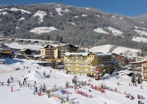 un grupo de personas en la nieve en una estación de esquí en Hotel Kohlerhof, en Fügen