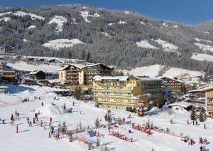 un gruppo di persone sulla neve in una stazione sciistica di Hotel Kohlerhof a Fügen