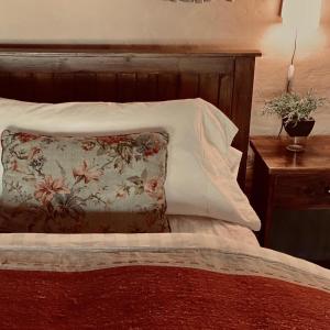 a bed with a floral pillow and a wooden headboard at Rancho de los Esteros in Colonia Carlos Pellegrini