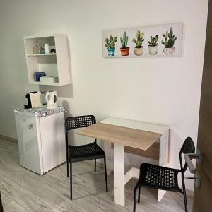 een keuken met een tafel en stoelen en een koelkast bij Sa domu rubia in Iglesias