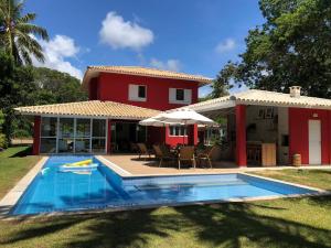 a house with a swimming pool in front of a house at Casa Complexo Costa do Sauípe in Costa do Sauipe