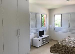 um quarto com uma cama e uma secretária com um computador em Casa Complexo Costa do Sauípe na Costa do Sauípe