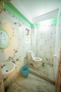 a bathroom with a toilet and a sink and a tub at Tirupati Lodge NJP in Siliguri