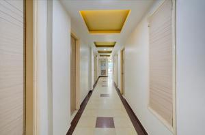 a hallway with white walls and a yellow ceiling at Hotel Mahadev Palace in Deoghar