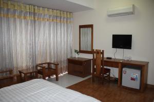 a bedroom with a bed and a desk and a television at An Phú Motel in Hanoi