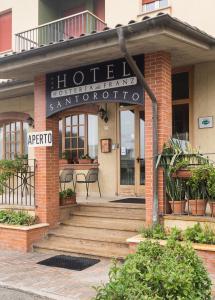 un hôtel avec un panneau à l'avant d'un bâtiment dans l'établissement Hotel Santorotto, à Sinalunga
