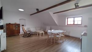ein Wohnzimmer mit einem Tisch, Stühlen und einem Fenster in der Unterkunft Ferienhof-Kühn in Hochkirch