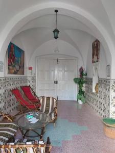 uma sala de estar com um sofá e uma mesa de vidro em Dar El Goulli em Hammam Sousse