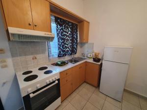 a kitchen with a white stove and a refrigerator at Countryside Studios in Ayia Evfimia