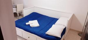 a small bed with blue sheets and white pillows at B&B Porta Nuova in Palermo