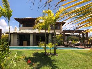 a house with a swimming pool and palm trees at Casa Praia do Forte - Piscinas naturais in Farol