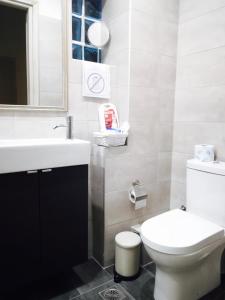uma casa de banho com um WC branco e um lavatório. em Hermes Apartment - Athens Int Airport em Artemida