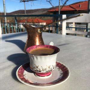 a cup of coffee on a plate on a table at Acrotel Sofia's Guest House in Sidherás