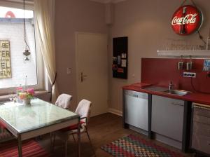 una cucina con bancone, tavolo e lavandino di LOFTvorSYLT a Friedrichstadt