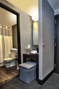 a bathroom with a toilet and a sink and a stool at Lord Baltimore Hotel in Baltimore