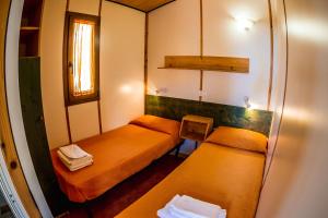 Habitación pequeña con 2 camas y ventana en Agriturismo Valle di Marco en Palinuro