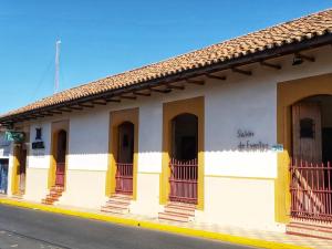 un bâtiment avec des portes et des balcons jaunes dans une rue dans l'établissement Hotel La Posada del Doctor, à León