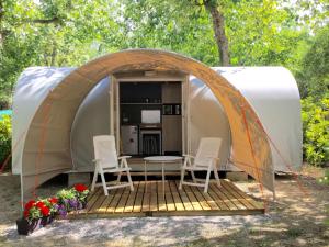 tenda con sedie e tavolo di fronte ad essa di Camping Village Oasi ad Albinia