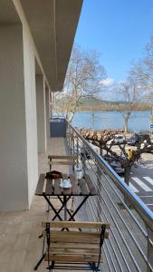 un balcón con 2 mesas y bancos en un edificio en JASALPI único apartamento delante del Lago de Banyoles, en Banyoles