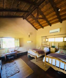 a bedroom with two beds and a table at Rancho de los Esteros in Colonia Carlos Pellegrini
