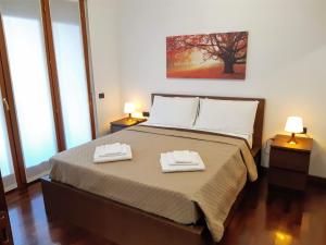 sypialnia z łóżkiem i dwoma ręcznikami na nim w obiekcie Suite Rent Milan w Mediolanie +34 zdjęcia
