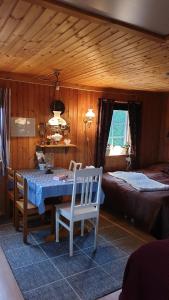 a room with a table and chairs and a bed at Lillesjö stuguthyrning in Bäckefors
