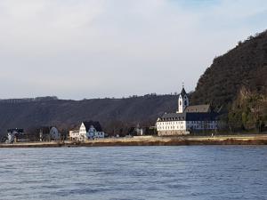 a large building on the shore of a body of water at Ferienwohnung Rheinzeit beim Toni mit Terrasse und Balkon mit Rheinblick in Boppard