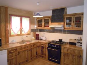 a kitchen with wooden cabinets and a stove top oven at LES MARMOTTES in Gez