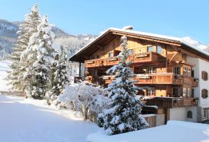 a log cabin in the snow with trees at Chalet Tannenhof in Lermoos