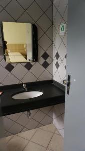a bathroom with a sink and a mirror at Cafe e Almoço Hotel Thermas da Affego in Caldas Novas