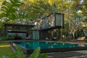 a glass house with a swimming pool in the middle at The Box House in Tangalle