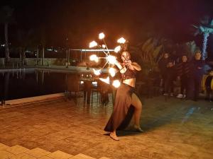 a woman is dancing with fire sparklers on a stage at Oasi del Fauno in Casal Velino